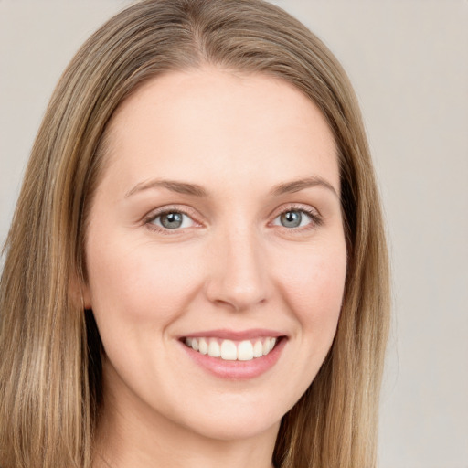 Joyful white young-adult female with long  brown hair and grey eyes