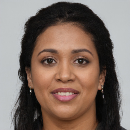 Joyful latino adult female with long  brown hair and brown eyes