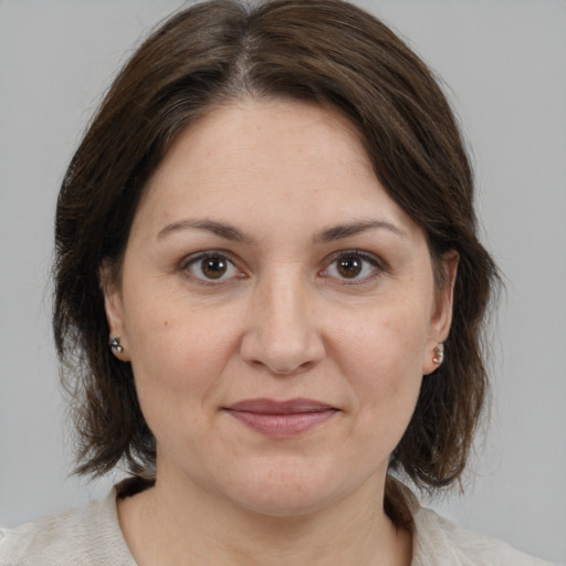 Joyful white adult female with medium  brown hair and brown eyes