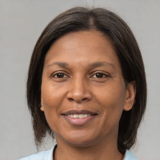 Joyful latino adult female with medium  brown hair and brown eyes