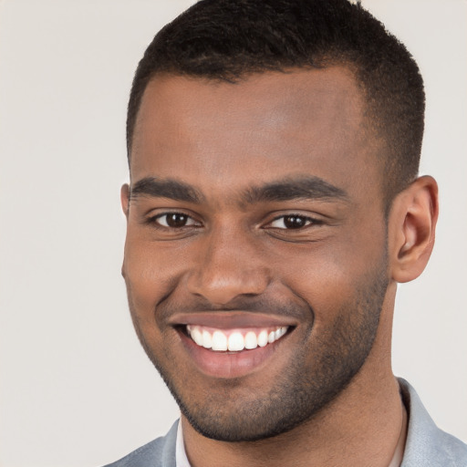 Joyful black young-adult male with short  brown hair and brown eyes