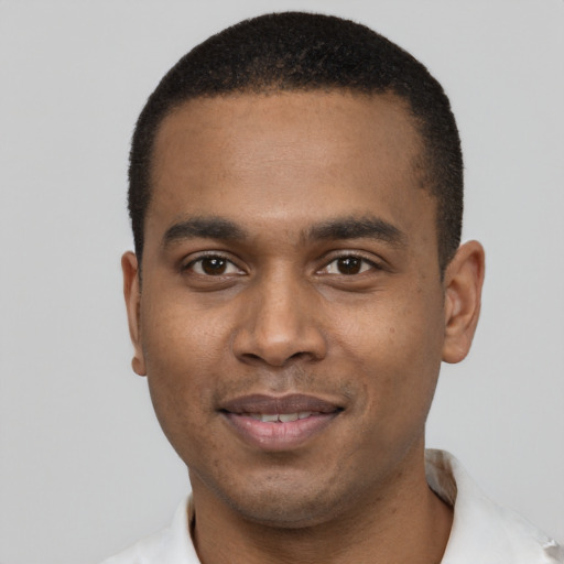 Joyful black young-adult male with short  black hair and brown eyes