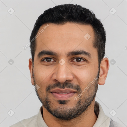 Joyful latino young-adult male with short  black hair and brown eyes