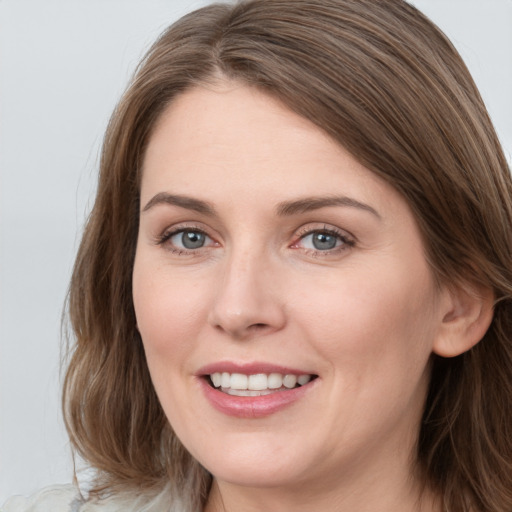 Joyful white young-adult female with long  brown hair and grey eyes