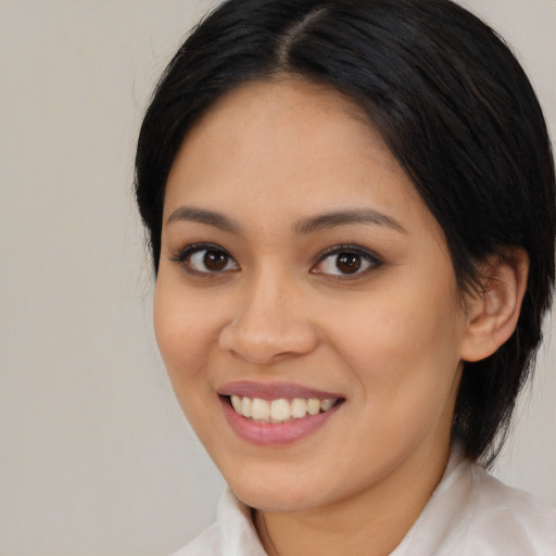 Joyful latino young-adult female with medium  black hair and brown eyes