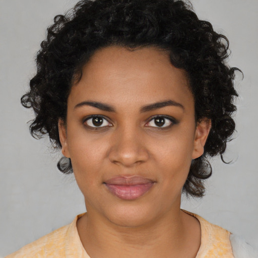 Joyful black young-adult female with short  black hair and brown eyes