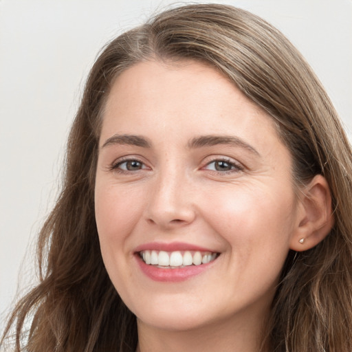 Joyful white young-adult female with long  brown hair and grey eyes