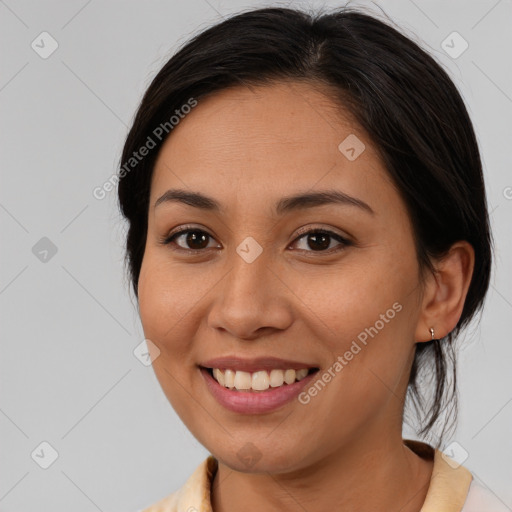 Joyful latino young-adult female with medium  brown hair and brown eyes