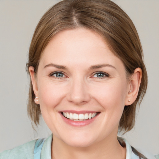 Joyful white young-adult female with medium  brown hair and blue eyes