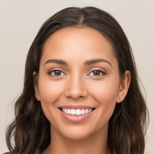 Joyful white young-adult female with long  brown hair and brown eyes