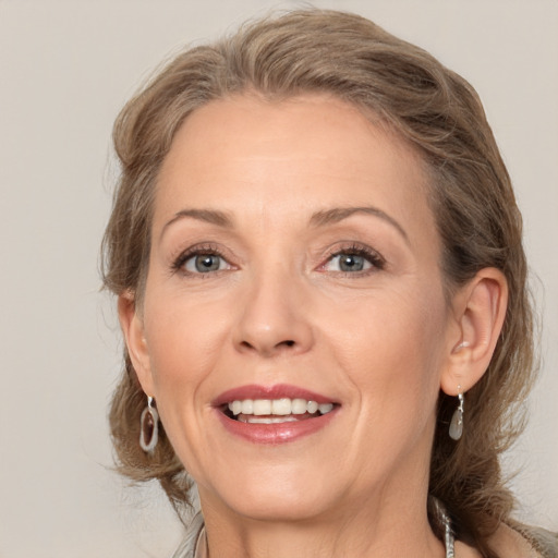 Joyful white adult female with medium  brown hair and grey eyes