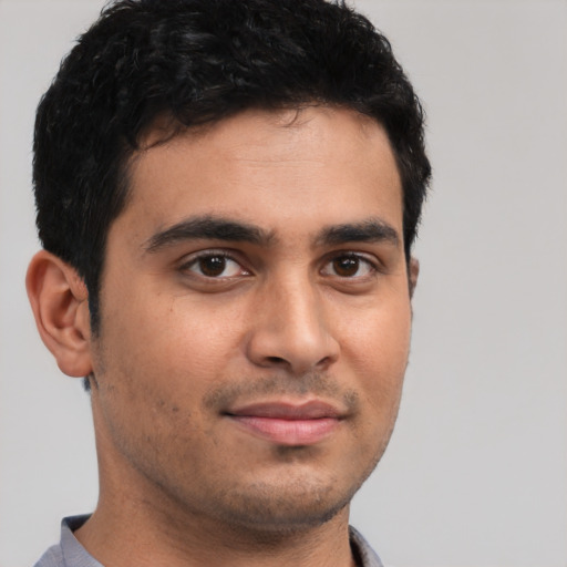 Joyful latino young-adult male with short  brown hair and brown eyes