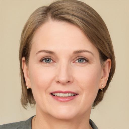 Joyful white adult female with medium  brown hair and grey eyes