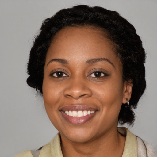 Joyful black adult female with medium  black hair and brown eyes