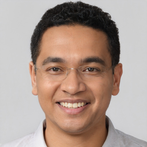 Joyful latino young-adult male with short  brown hair and brown eyes