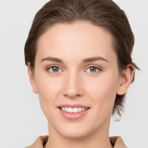 Joyful white young-adult female with medium  brown hair and grey eyes