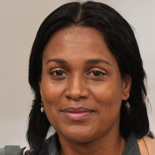 Joyful black adult female with medium  brown hair and brown eyes
