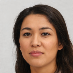 Joyful latino young-adult female with long  brown hair and brown eyes