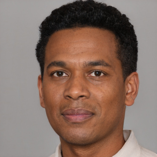 Joyful black young-adult male with short  black hair and brown eyes