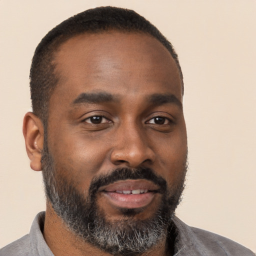 Joyful black young-adult male with short  brown hair and brown eyes