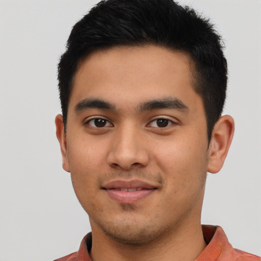 Joyful latino young-adult male with short  black hair and brown eyes