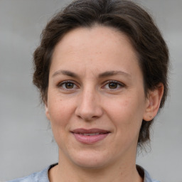 Joyful white adult female with medium  brown hair and brown eyes