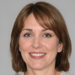 Joyful white adult female with medium  brown hair and blue eyes