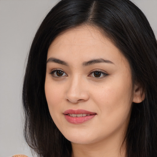 Joyful asian young-adult female with long  black hair and brown eyes