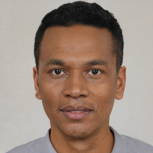 Joyful black young-adult male with short  black hair and brown eyes