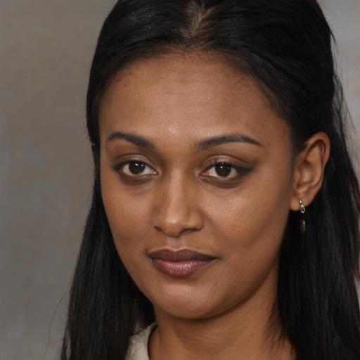 Joyful black young-adult female with long  brown hair and brown eyes
