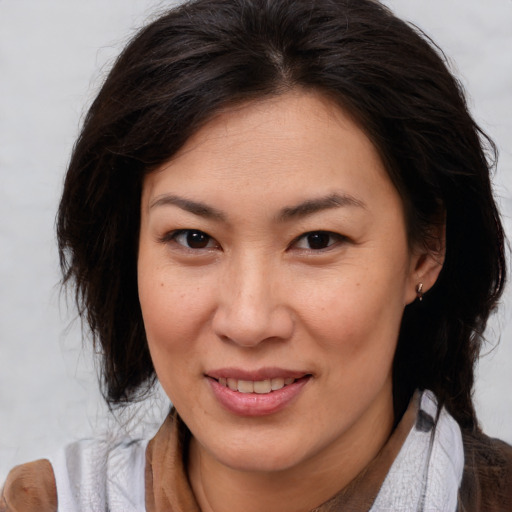 Joyful asian adult female with medium  brown hair and brown eyes