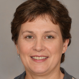 Joyful white adult female with medium  brown hair and grey eyes