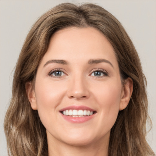 Joyful white young-adult female with long  brown hair and green eyes