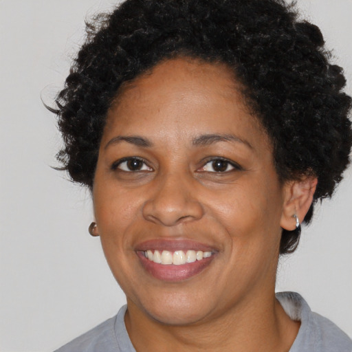 Joyful black adult female with short  black hair and brown eyes
