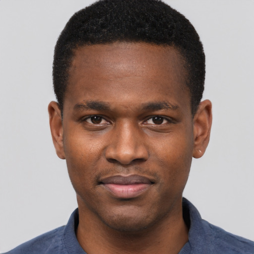 Joyful black young-adult male with short  black hair and brown eyes