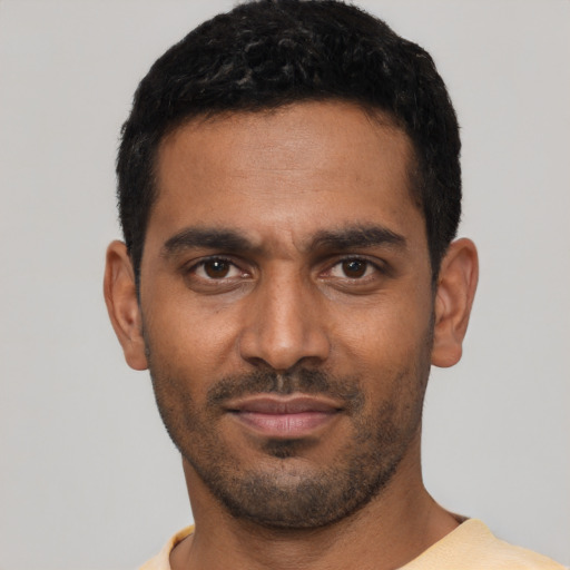 Joyful black young-adult male with short  black hair and brown eyes