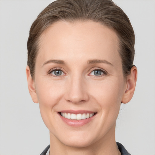 Joyful white young-adult female with short  brown hair and grey eyes