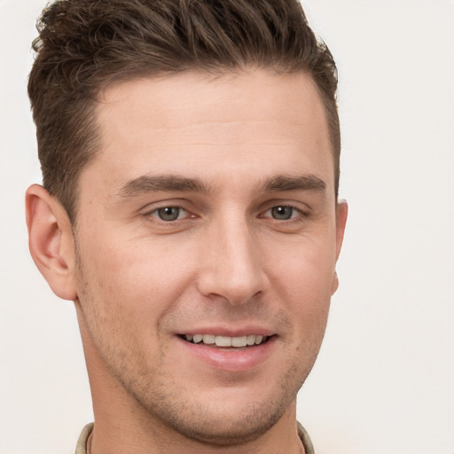 Joyful white young-adult male with short  brown hair and grey eyes