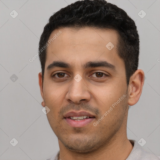 Joyful latino young-adult male with short  black hair and brown eyes