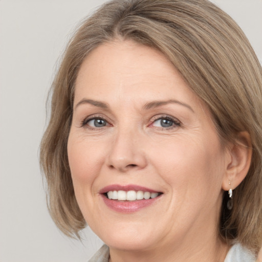 Joyful white adult female with medium  brown hair and grey eyes