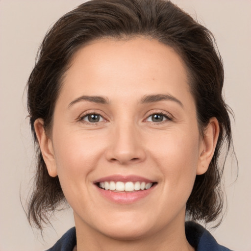 Joyful white young-adult female with medium  brown hair and brown eyes