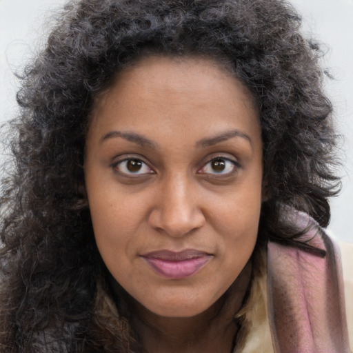 Joyful black young-adult female with long  brown hair and brown eyes