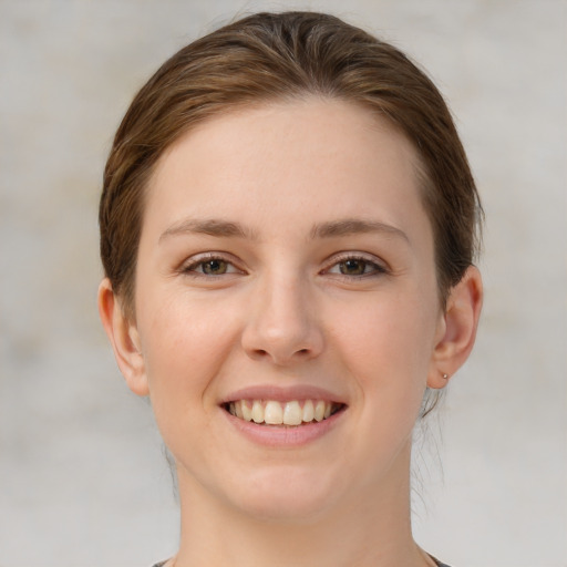 Joyful white young-adult female with short  brown hair and green eyes