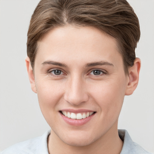 Joyful white young-adult female with short  brown hair and grey eyes