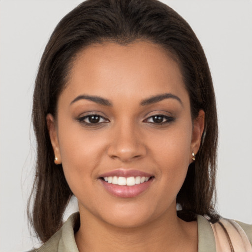 Joyful latino young-adult female with long  brown hair and brown eyes