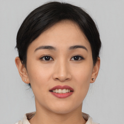 Joyful asian young-adult female with short  brown hair and brown eyes