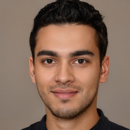Joyful latino young-adult male with short  black hair and brown eyes