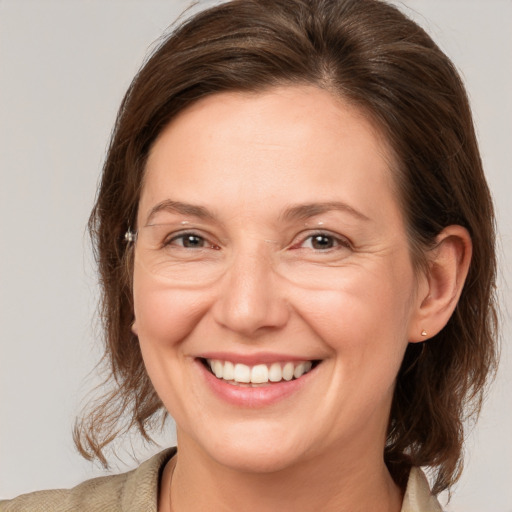 Joyful white adult female with medium  brown hair and brown eyes