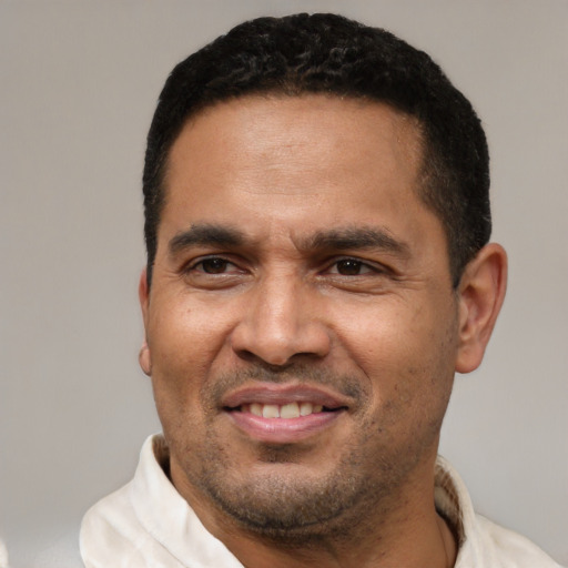 Joyful latino adult male with short  brown hair and brown eyes