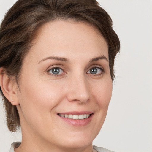 Joyful white young-adult female with short  brown hair and grey eyes